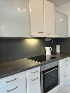 a kitchen with white cabinets and a stove top oven at Beishan Appartements Nürnberg in Nürnberg