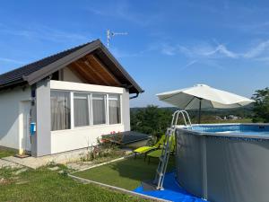een huis met een zwembad en een parasol bij Holiday Home Sunset in Grabrovnik