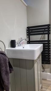 a white sink in a bathroom next to a shower at The Studio in Climping in Climping