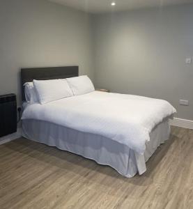 a bedroom with a large bed with white sheets at The Studio in Climping in Climping