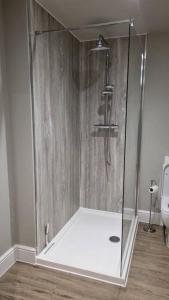 a shower with a glass enclosure in a bathroom at The Studio in Climping in Climping