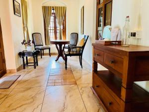 a room with chairs and a table and a dresser at Nature Sanctuary Urumbi Hills in Mundakāyam