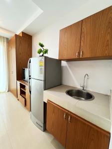 a kitchen with a sink and a refrigerator at S303 Good Apartment Chalong Na-kok in Phuket Town