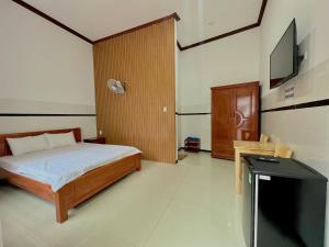 a bedroom with a bed and a flat screen tv at BeachSide House Mui Ne II in Ấp Khánh Phước (1)