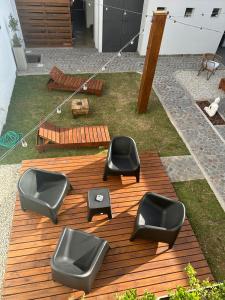 un grupo de sillas negras en una terraza de madera en Lo de Carlos en Santa Teresita