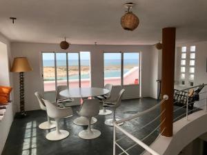 a dining room with a table and chairs and a view of the beach at Dar Dielna in Oualidia