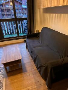 1 cama y 1 mesa en una habitación con ventana en Valfrejus Studio 19m2 cosy 60 m des pistes draps non compris, en Modane