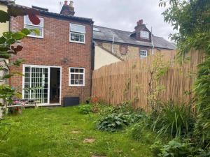 a wooden fence in front of a house at Bumblebee Cottage - Cosy Cottage in Area of Outstanding Natural Beauty in Hemel Hempstead