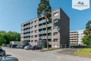 a large building with cars parked in a parking lot at Romantiline Haapsalu ootab Sind in Haapsalu