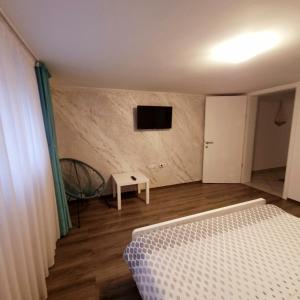 a bedroom with a bed and a tv on a wall at Apartment Kapetanovic in Bosanski Šamac