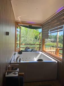 a large bath tub in a room with a window at Haus Palazzo in Bosanska Krupa