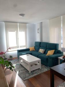 a living room with a blue couch and a coffee table at Apartamento en Liencres in Liencres