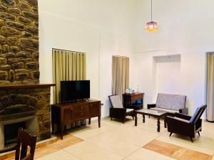 a living room with a fireplace and a tv at Nature Sanctuary Urumbi Hills in Mundakāyam