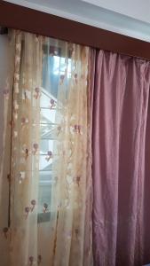a window with a curtain with flowers on it at Jetpoint- Central Nadi 2 bedrm in Nadi