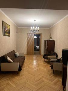 sala de estar con sofá y sillas en apartment N&A en Tiflis