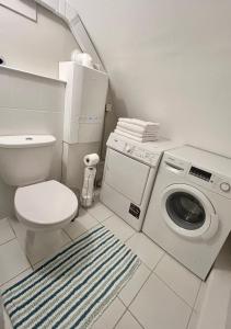 ein Badezimmer mit einem WC und einer Waschmaschine in der Unterkunft East Finchley N2 apartment close to Muswell Hill & Alexandra Palace with free parking on-site in London