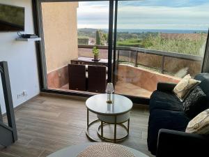 a living room with a couch and a table at Appartement Sanary vue mer au calme in Sanary-sur-Mer