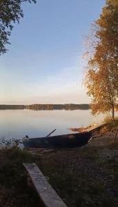 a canoe sitting on the shore of a lake at Hanhi Linna in Taivalkoski