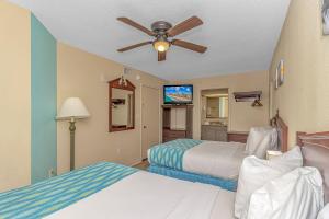 Habitación de hotel con 2 camas y ventilador de techo. en Atlantica 757, en Myrtle Beach