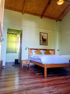 1 dormitorio con 1 cama grande y suelo de madera en Chirping Orchard, Mukteshwar en Mukteswar