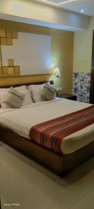 - un grand lit dans une chambre dans l'établissement Orbit Hotel, à Bāghdogra