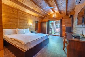 1 dormitorio con 1 cama grande en una habitación de madera en marron sea view resort, en Palolem