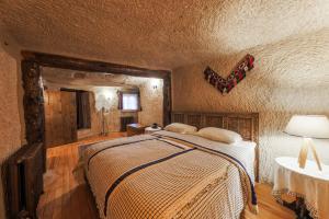 格雷梅的住宿－卡帕多西亞岩洞套房酒店，卧室配有一张床,墙上挂着蝴蝶