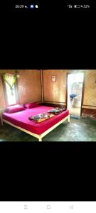 Cama en habitación con colcha púrpura en Rakkan Resort en Ko Phra Thong