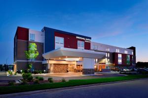 SpringHill Suites by Marriott Grand Rapids West في غراندفيل: مبنى كبير وامامه موقف سيارات