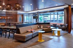 a lobby with a couch and tables and a restaurant at SpringHill Suites by Marriott Grand Rapids West in Grandville