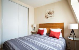 a bedroom with a bed with two red pillows at Place de l'Etoile, Wagram in Paris