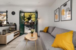 een woonkamer met een bank en een tafel bij Nordik Apartments Urban - Pedregalejo "Reine" in Málaga