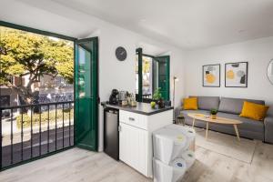 een keuken en een woonkamer met een bank en een tafel bij Nordik Apartments Urban - Pedregalejo "Reine" in Málaga