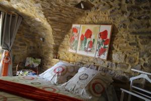 1 dormitorio con 1 cama en una pared de piedra en Chambre Cévennole, en Saint-Jean-de-Ceyrargues