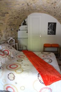 1 dormitorio con 1 cama en una pared de piedra en Chambre Cévennole, en Saint-Jean-de-Ceyrargues