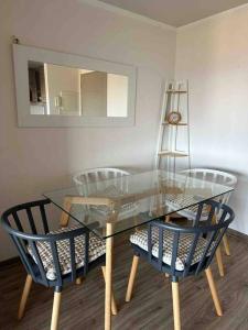 mesa de comedor de cristal con 2 sillas y espejo en Depto viña del mar Horizonte Infinito, en Viña del Mar