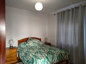 1 dormitorio con 1 cama con edredón verde en Rochinha House, en Funchal