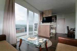 uma sala de estar com uma mesa de vidro e uma grande janela em Chic&Cozy Apartment in Nessebar em Nessebar