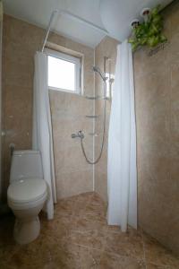 uma casa de banho com um WC e um chuveiro com uma janela em Chic&Cozy Apartment in Nessebar em Nessebar