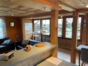 a kitchen and living room with a couch and a table at Edelweiss 4 Zi Ferienwohnung in Landhaus in Frutigen