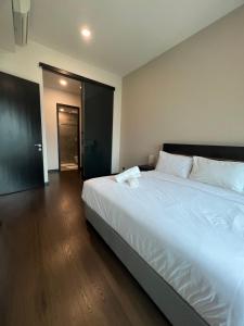 a bedroom with a large white bed with a wooden floor at Opus Residences Merdeka 118 View in Kuala Lumpur
