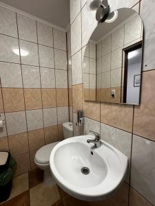 a bathroom with a sink and a toilet and a mirror at Dom Pod Lipą in Rymanów-Zdrój