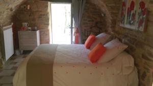 1 dormitorio con cama blanca y almohadas rojas en Chambre Cévennole, en Saint-Jean-de-Ceyrargues