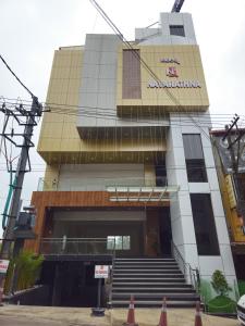 a building with a sign on the side of it at Navarathna Comforts in Madikeri