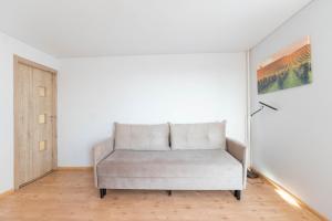 - un canapé blanc dans une pièce ornée d'une peinture murale dans l'établissement Šeškinės 61 Spacious Cozy Apartment, à Vilnius