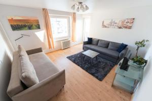 a living room with a couch and a table at Šeškinės 61 Spacious Cozy Apartment in Vilnius