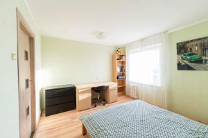 a bedroom with a bed and a desk and a window at Šeškinės 61 Spacious Cozy Apartment in Vilnius