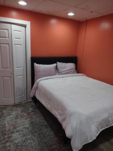 um quarto com uma cama com uma parede laranja em Unique Center Of Downtown Elmira em Elmira