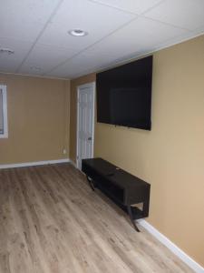 a living room with a flat screen tv on the wall at Unique Center Of Downtown Elmira in Elmira