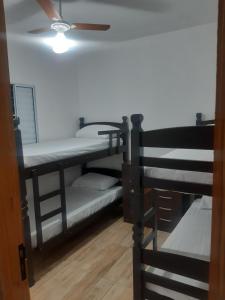 two bunk beds in a room with a ceiling fan at Acomodações Souza in Ilhabela +19 photos